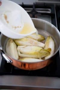 Ajouter le jus de citron et un peu d'eau aux endives.