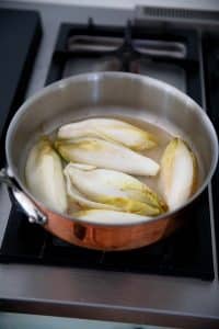 Braiser les endives dans le jus de citron et un peu d'eau.